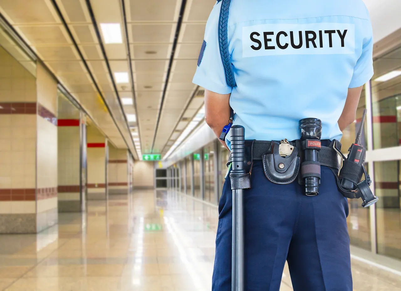 A security guard standing in an empty building.